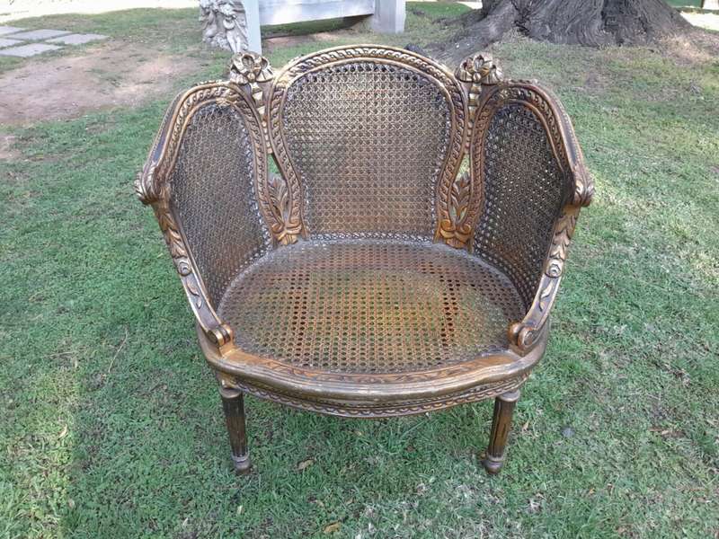 A French Louis XVI Style Pair of Ornately Carved Giltwood Rattan Bergere Chairs