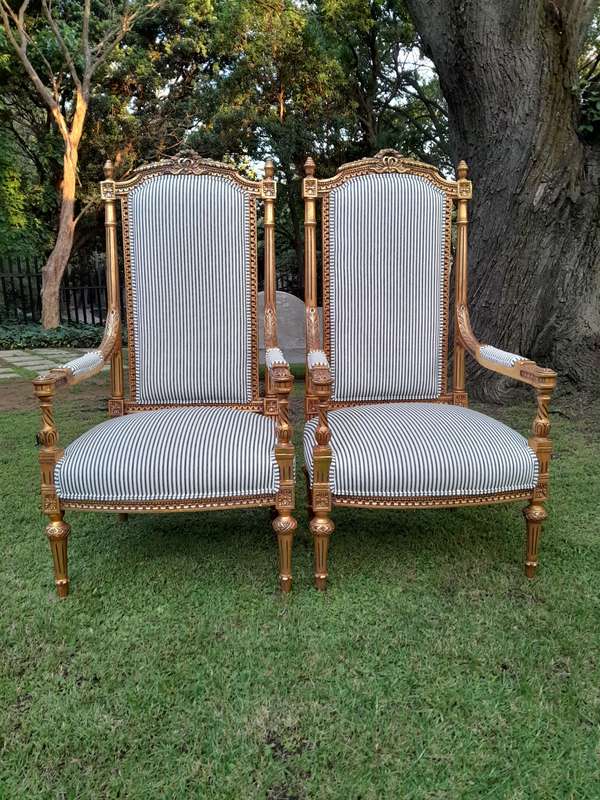 A Pair of French Rococo Style Ornately Carved Giltwood Arm Chairs Upholstered in a Contemporary T...
