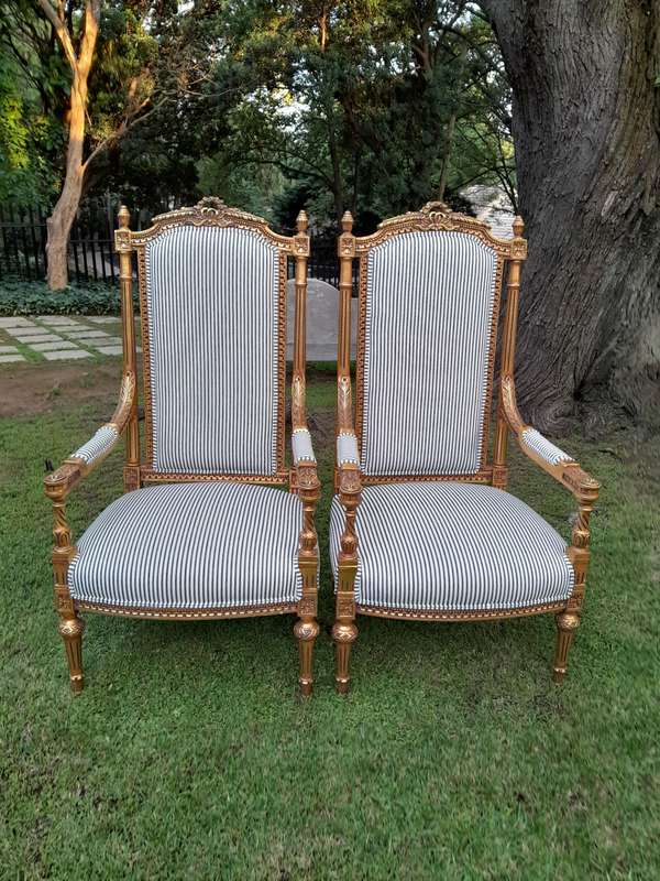 A Pair of French Rococo Style Ornately Carved Giltwood Arm Chairs Upholstered in a Contemporary T...