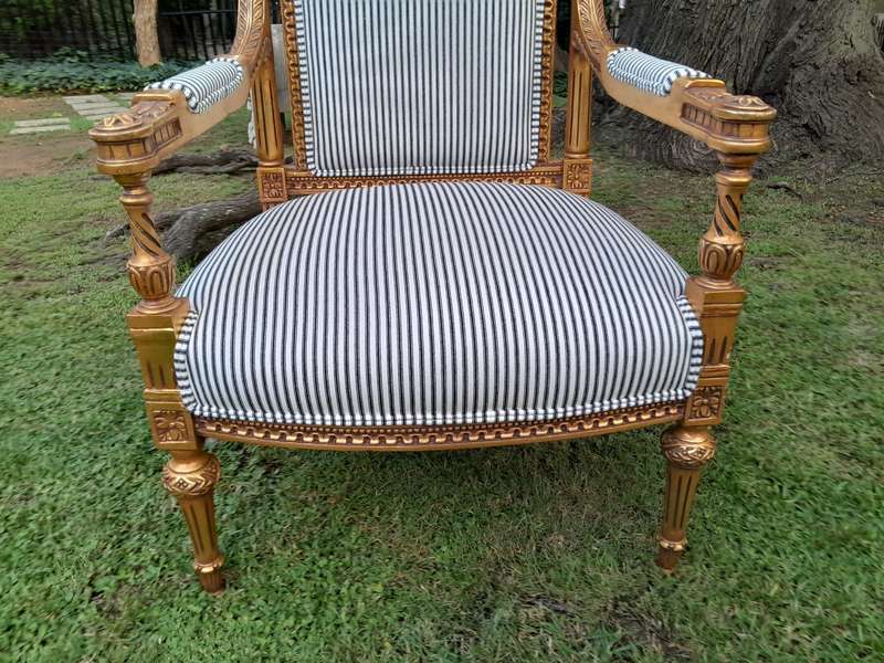 A Pair of French Rococo Style Ornately Carved Giltwood Arm Chairs Upholstered in a Contemporary T...