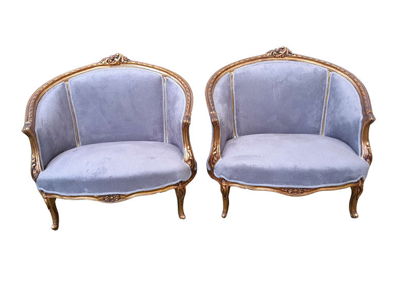 A Pair of French Ornately Carved and Gilded Bergere Chairs