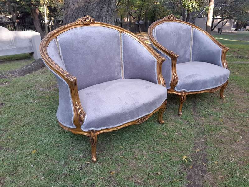A Pair of French Ornately Carved and Gilded Bergere Chairs