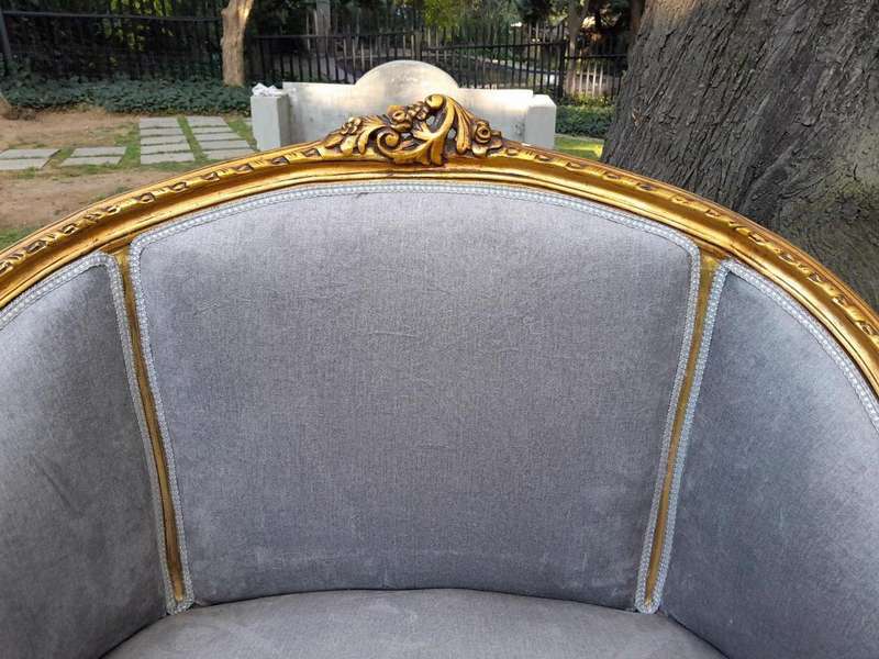 A Pair of French Ornately Carved and Gilded Bergere Chairs
