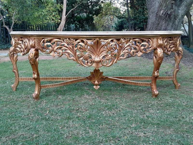 A 20th Century Ornately Carved and Hand-Gilded Console Table of Large Proportion with Cream Marbl...
