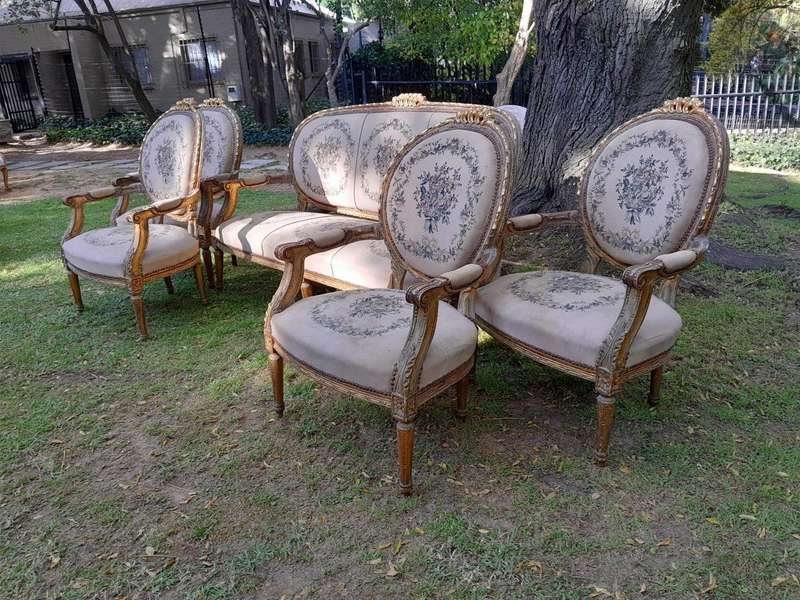 A 20th Century French Louis XVI Style Set of a Carved and Gilded Settee and Four Armchairs with T...