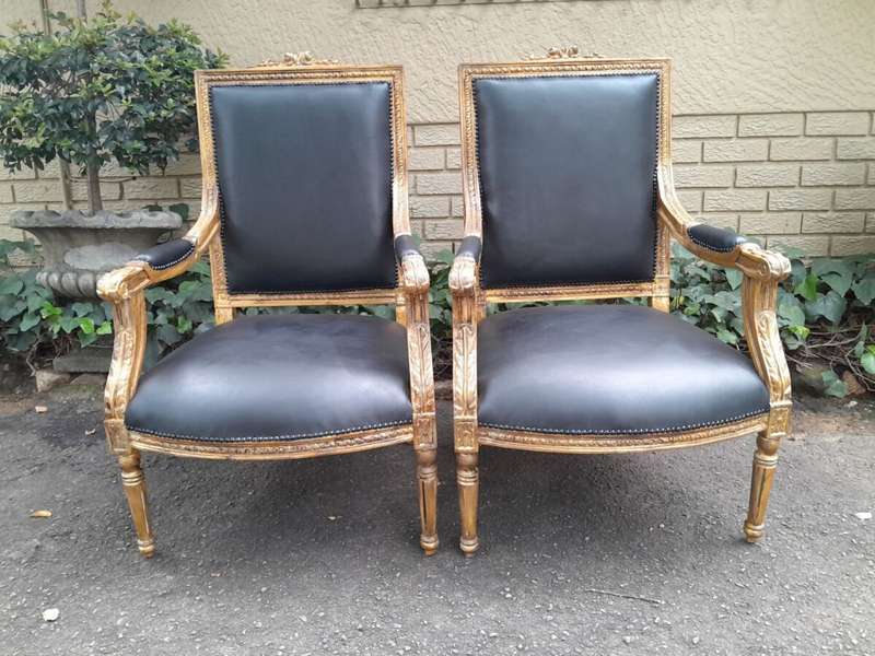 A 20th Century French Style Pair of Carved Gilt-Wood Arm Chairs Upholstered in Black Leather