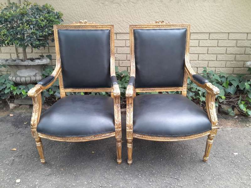 A 20th Century French Style Pair of Carved Gilt-Wood Arm Chairs Upholstered in Black Leather