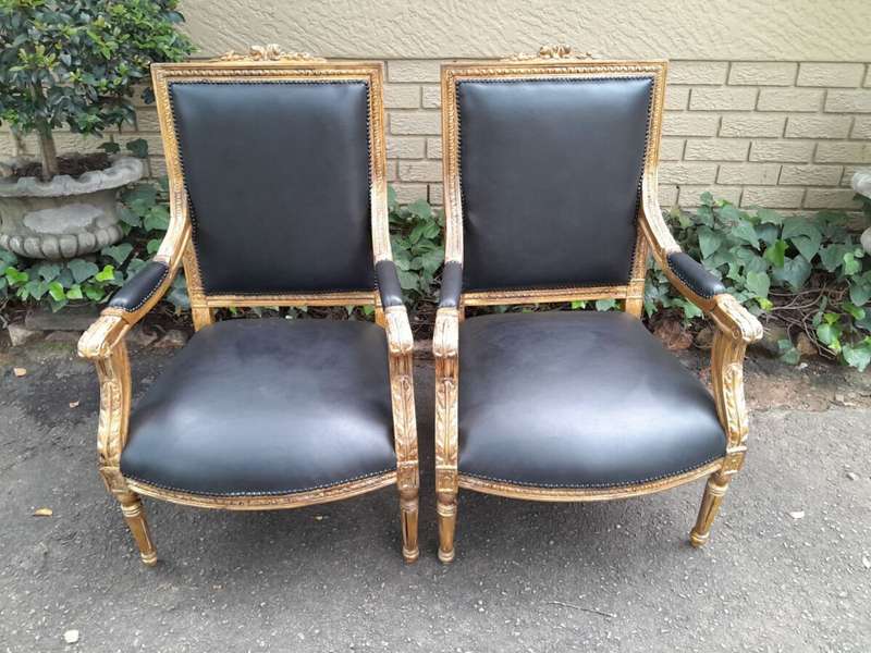 A 20th Century French Style Pair of Carved Gilt-Wood Arm Chairs Upholstered in Black Leather