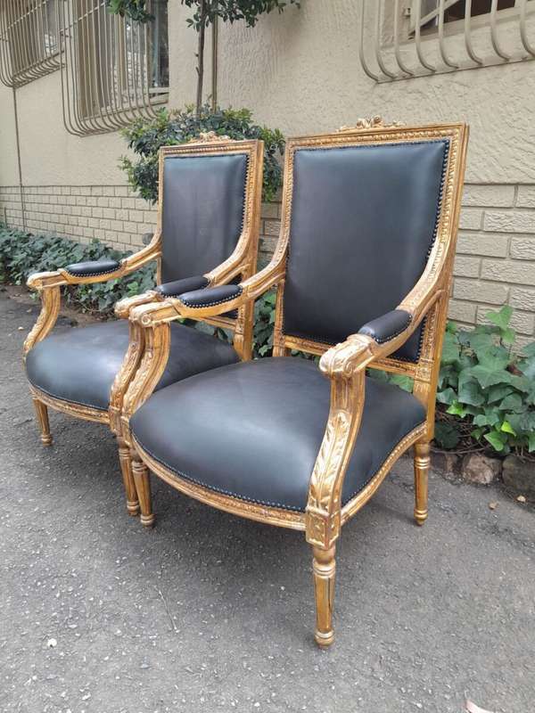 A 20th Century French Style Pair of Carved Gilt-Wood Arm Chairs Upholstered in Black Leather