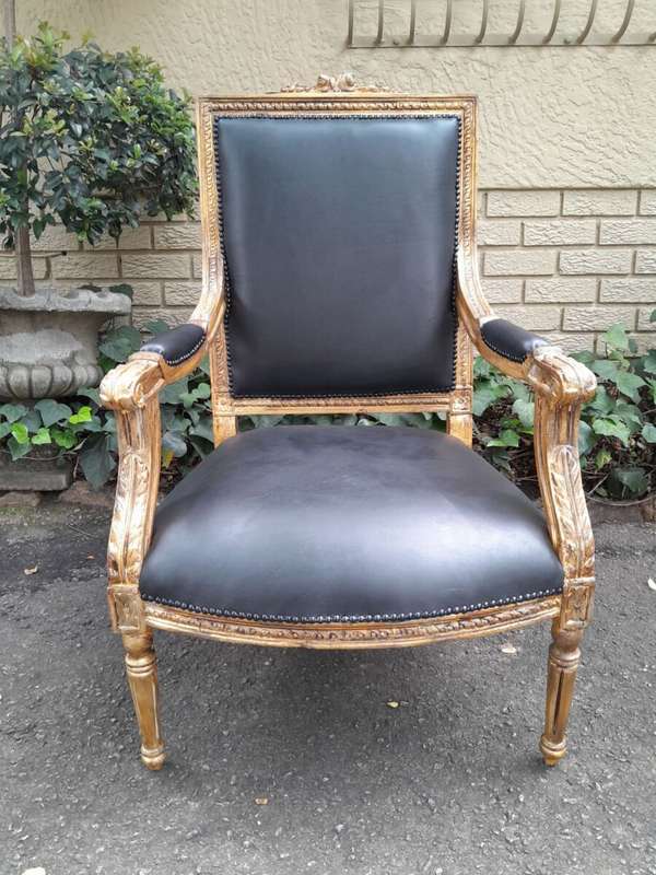 A 20th Century French Style Pair of Carved Gilt-Wood Arm Chairs Upholstered in Black Leather