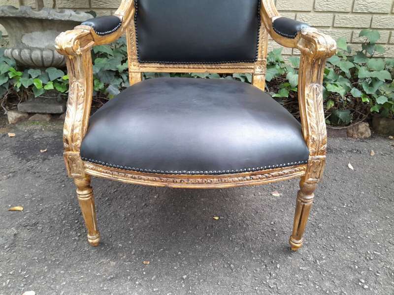 A 20th Century French Style Pair of Carved Gilt-Wood Arm Chairs Upholstered in Black Leather