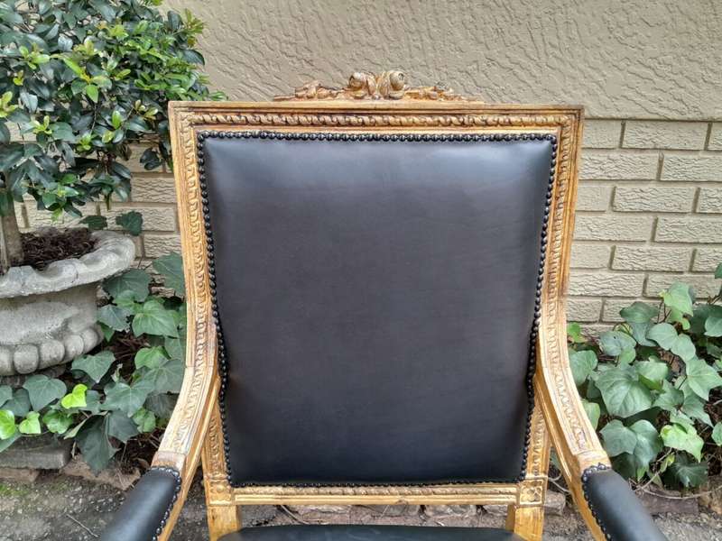 A 20th Century French Style Pair of Carved Gilt-Wood Arm Chairs Upholstered in Black Leather