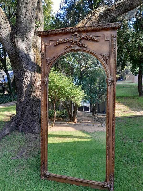A French Style Ornately Carved And Gilded Bevelled Mirror Of Large Proportions
