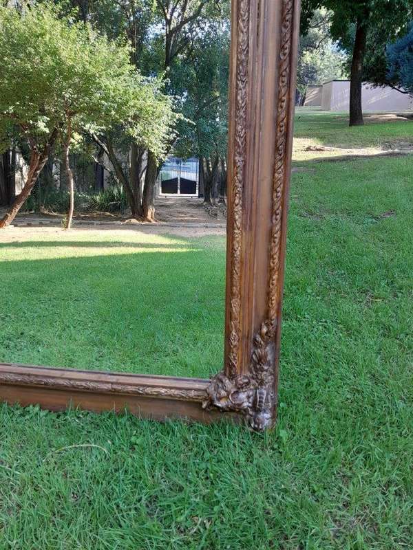 A French Style Ornately Carved And Gilded Bevelled Mirror Of Large Proportions
