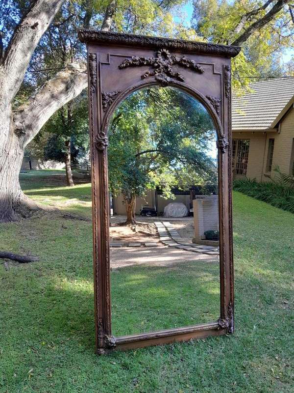 A French Style Ornately Carved and Gilded Bevelled Mirror of Large Proportions
