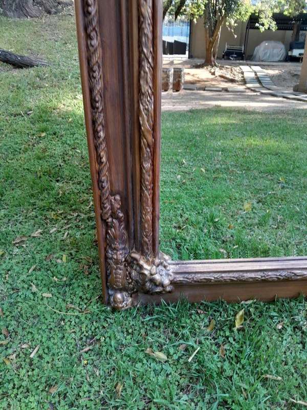 A French Style Ornately Carved and Gilded Bevelled Mirror of Large Proportions