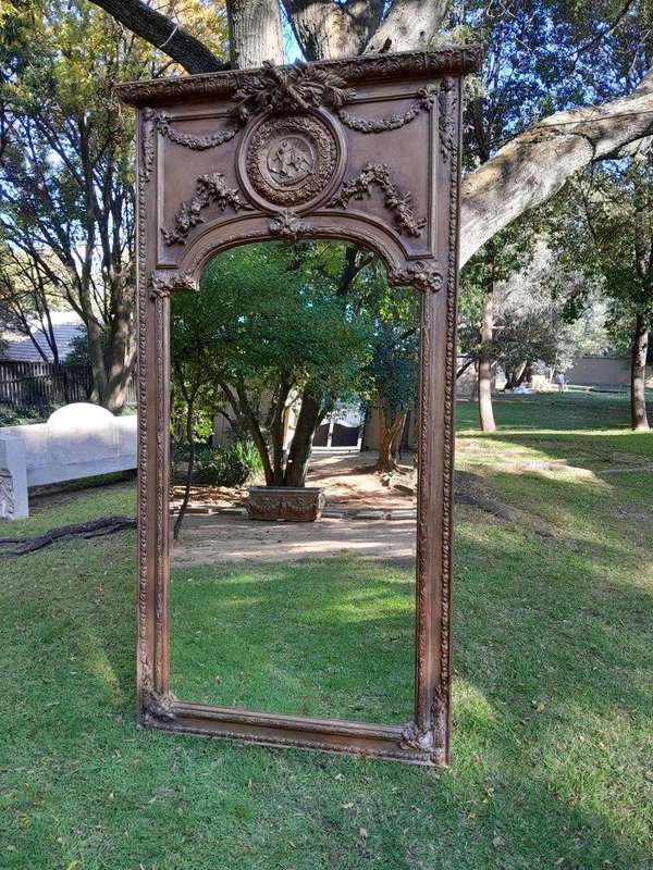 A French Style Ornately Carved and Gilded Bevelled Mirror of Large Proportions
