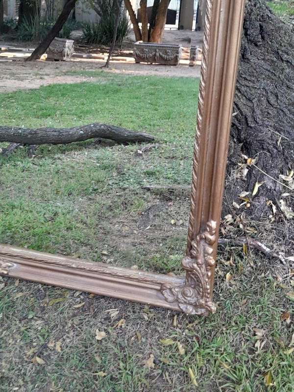 A French Style Ornately Carved and Gilded Bevelled Mirror of Large Proportions