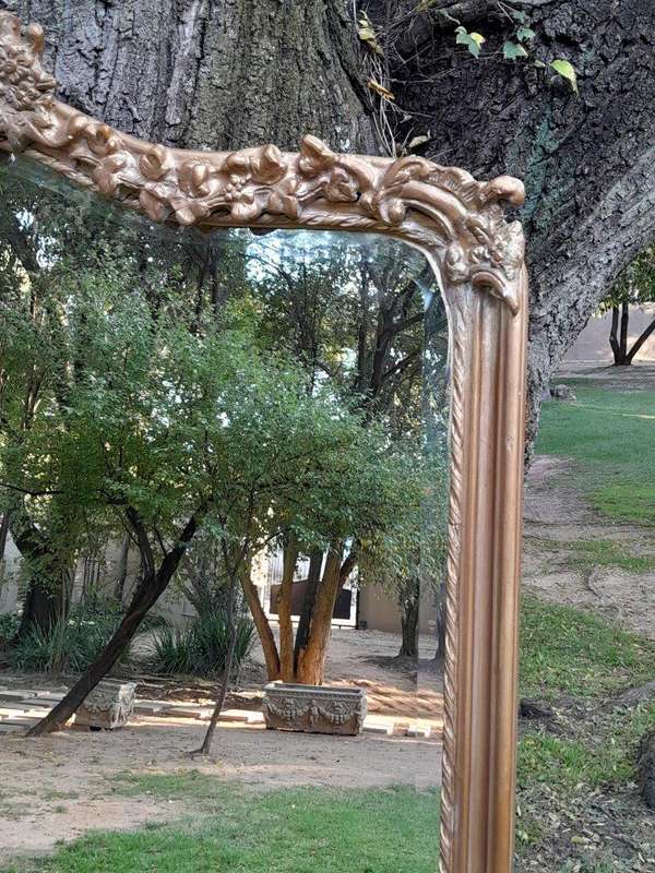 A French Style Ornately Carved and Gilded Bevelled Mirror of Large Proportions