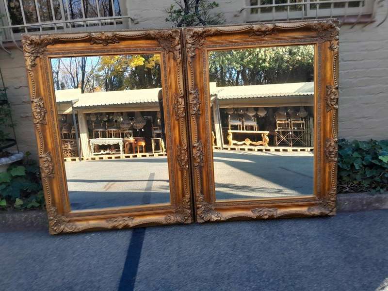 A 20th Century French Style Pair of Large and Ornately Carved Giltwood Mirrors