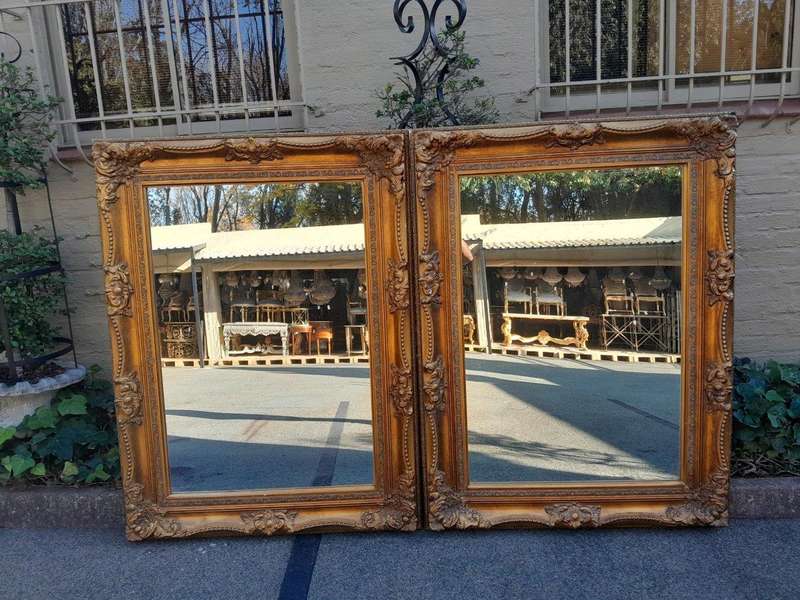 A 20th Century French Style Pair of Large and Ornately Carved Giltwood Mirrors