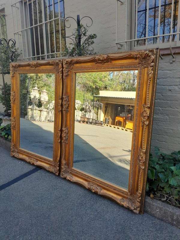 A 20th Century French Style Pair of Large and Ornately Carved Giltwood Mirrors