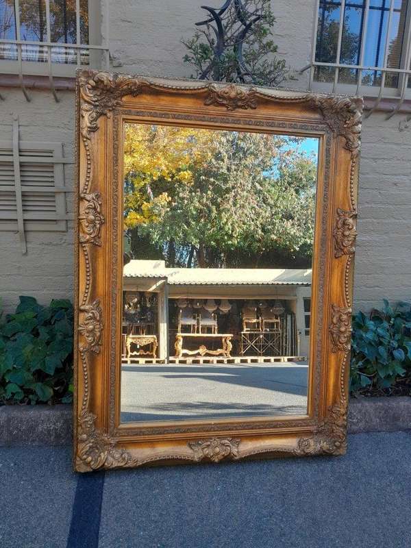 A 20th Century French Style Pair of Large and Ornately Carved Giltwood Mirrors