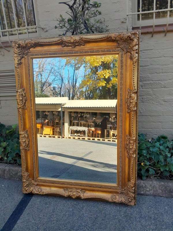 A 20th Century French Style Pair of Large and Ornately Carved Giltwood Mirrors