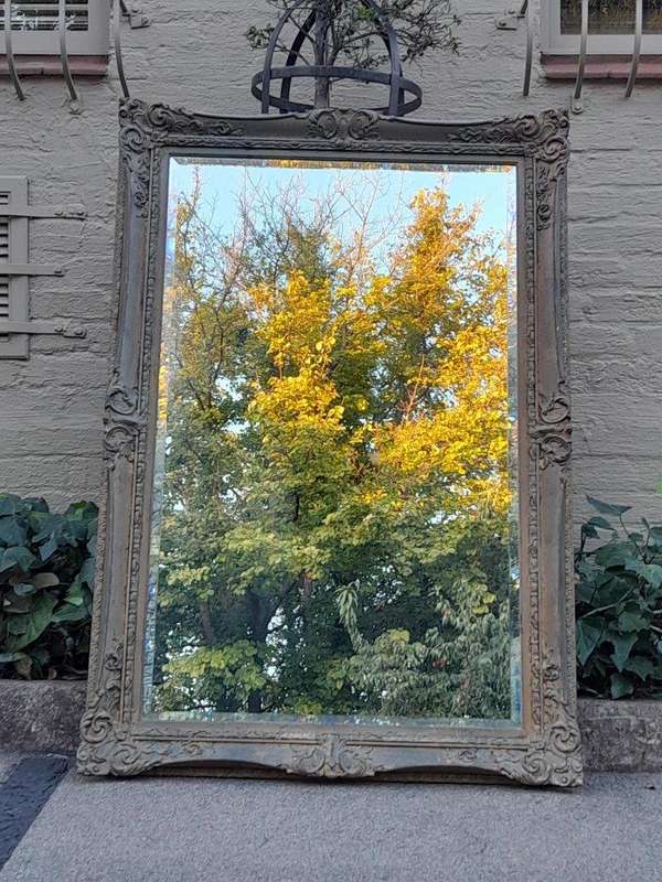 A 20th Century Large And Ornately Carved Gilded And Bevelled Mirror