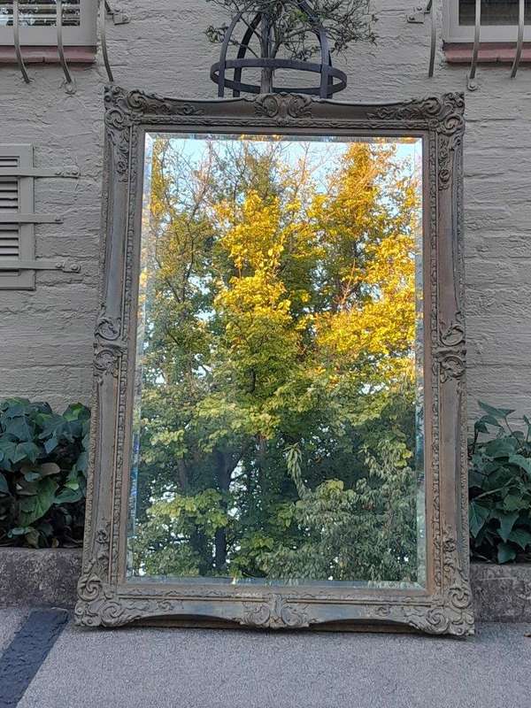A 20th Century Large And Ornately Carved Gilded And Bevelled Mirror