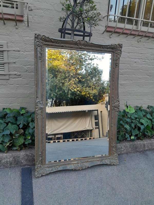 A 20th Century Large And Ornately Carved Gilded And Bevelled Mirror