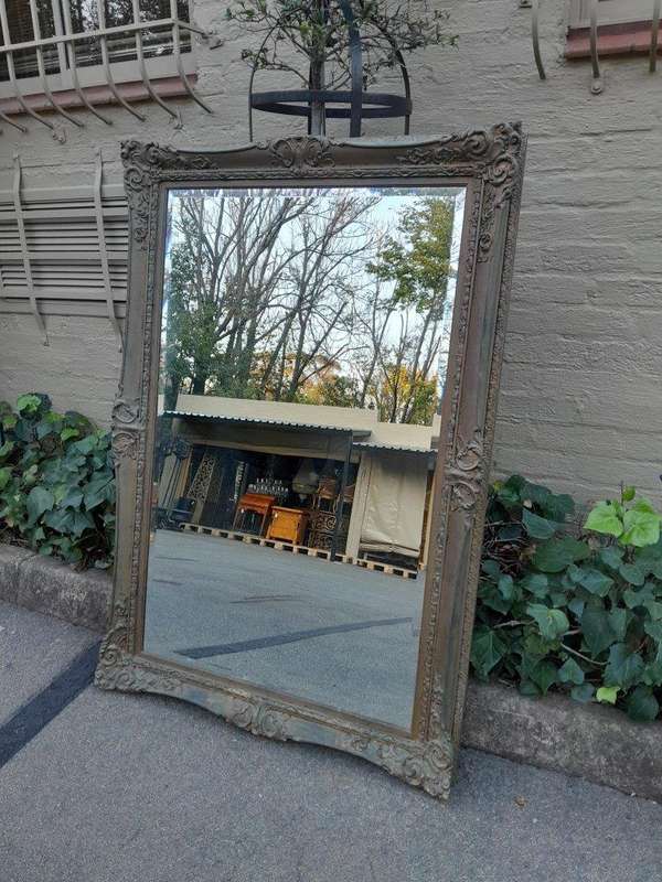 A 20th Century Large And Ornately Carved Gilded And Bevelled Mirror