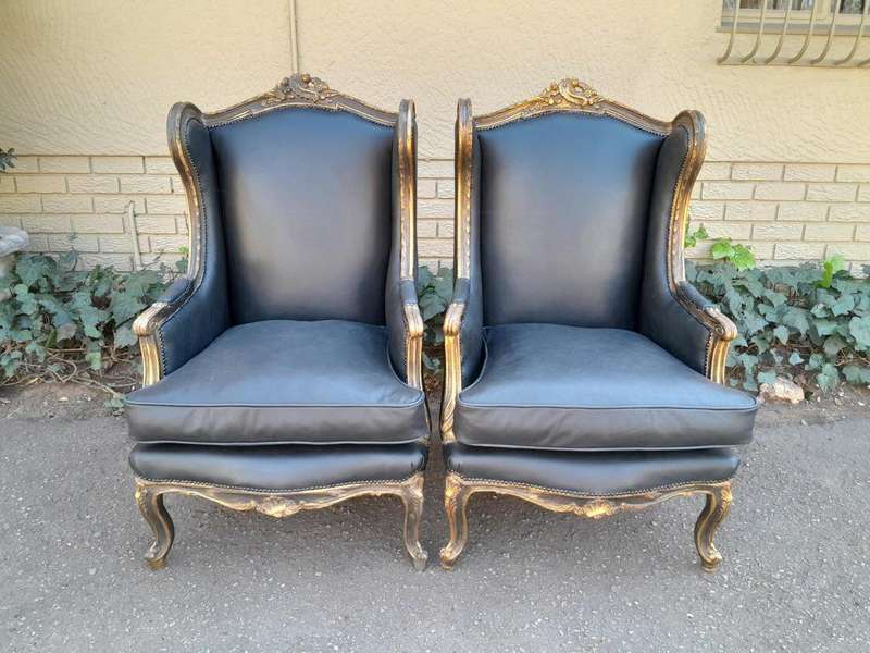 A Circa 1900s French Style Pair Of Carved Giltwood Wingback Chairs Upholstered In Leather