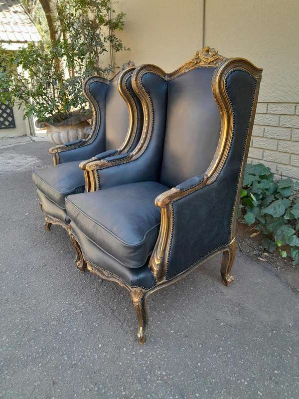 A Circa 1900s French Style Pair Of Carved Giltwood Wingback Chairs Upholstered In Leather