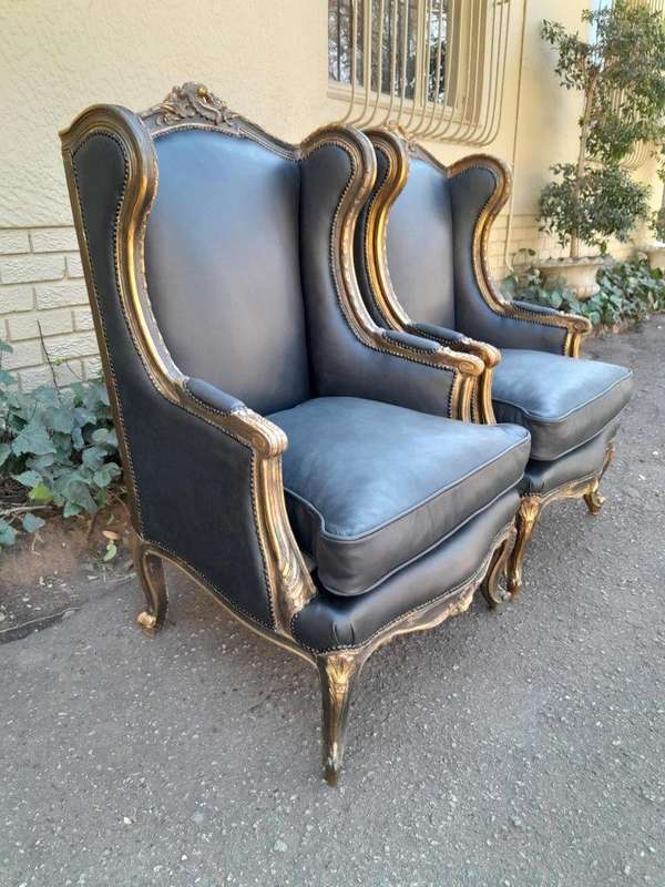 A Circa 1900s French Style Pair Of Carved Giltwood Wingback Chairs Upholstered In Leather