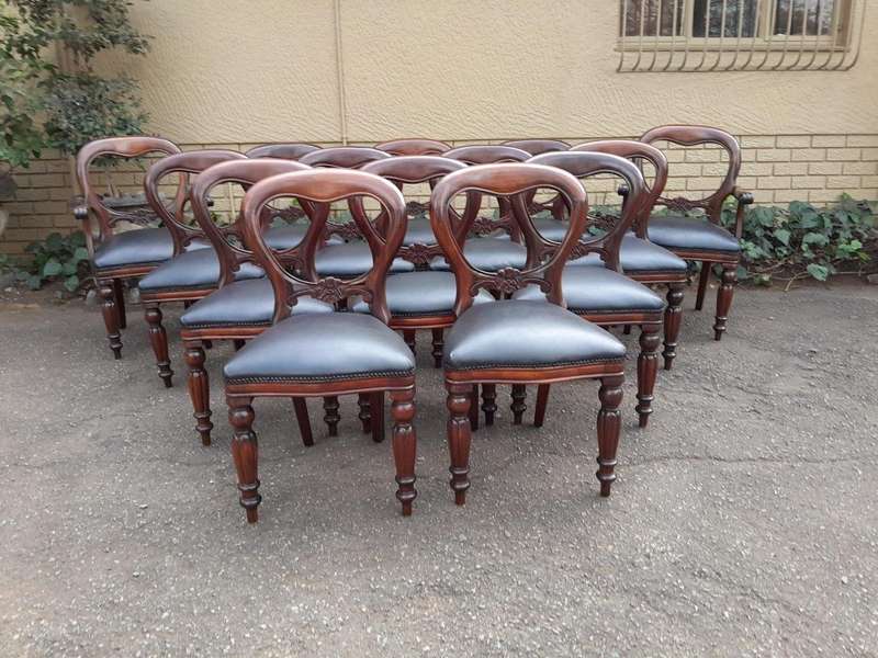 A 20th Century Set of Fourteen (14) Victorian Style Mahogany Bustle Back Chairs Upholstered in Le...