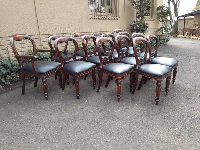 A 20th Century Set of Fourteen (14) Victorian Style Mahogany Bustle Back Chairs Upholstered in Le...
