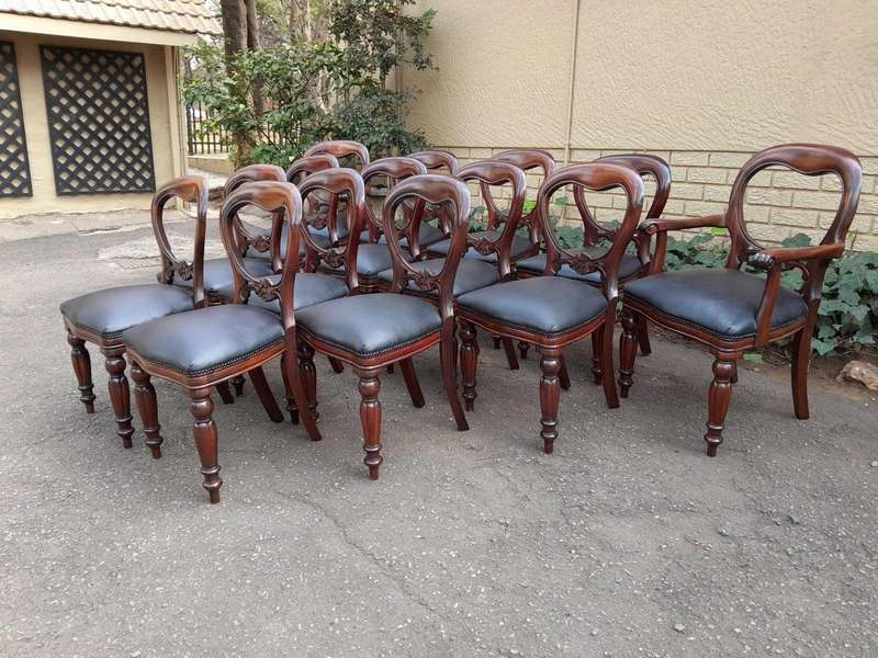 A 20th Century Set of Fourteen (14) Victorian Style Mahogany Bustle Back Chairs Upholstered in Le...