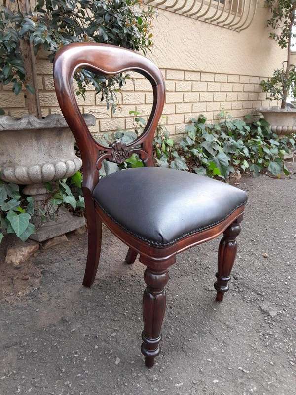A 20th Century Set of Fourteen (14) Victorian Style Mahogany Bustle Back Chairs Upholstered in Le...