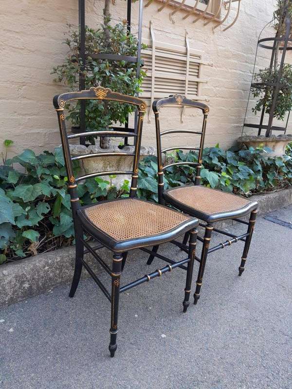 A Late 19th Century Circa 1880s Pair Of Victorian Ebonised And Gilt Painted Wooden Rattan Chairs