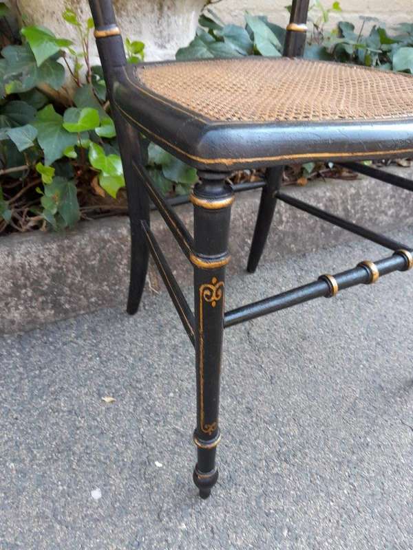 A Late 19th Century Circa 1880s Pair Of Victorian Ebonised And Gilt Painted Wooden Rattan Chairs