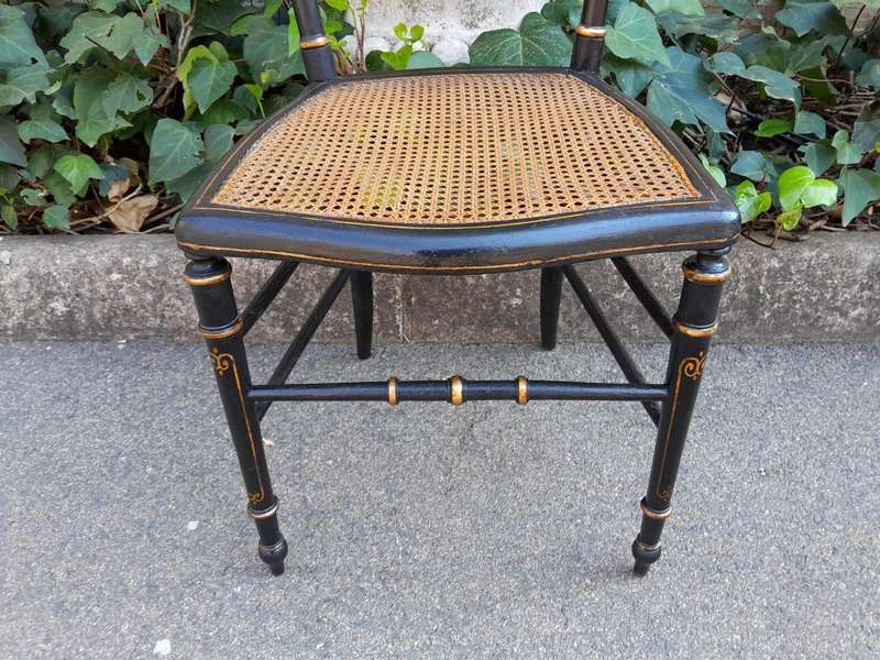 A Late 19th Century Circa 1880s Pair Of Victorian Ebonised And Gilt Painted Wooden Rattan Chairs