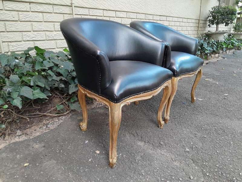 A French Style Pair of Carved Wooden and Hand-Gilded Tub Chairs Upholstered in Black Leather