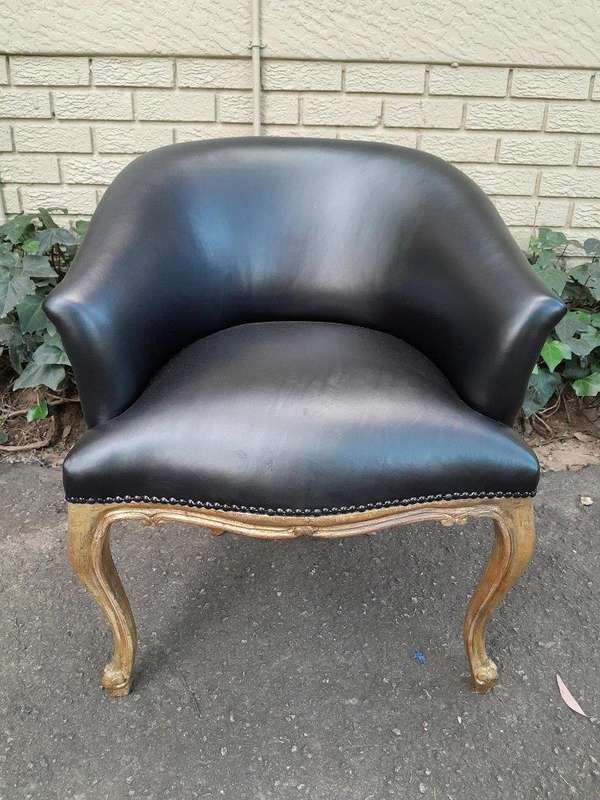 A French Style Pair of Carved Wooden and Hand-Gilded Tub Chairs Upholstered in Black Leather