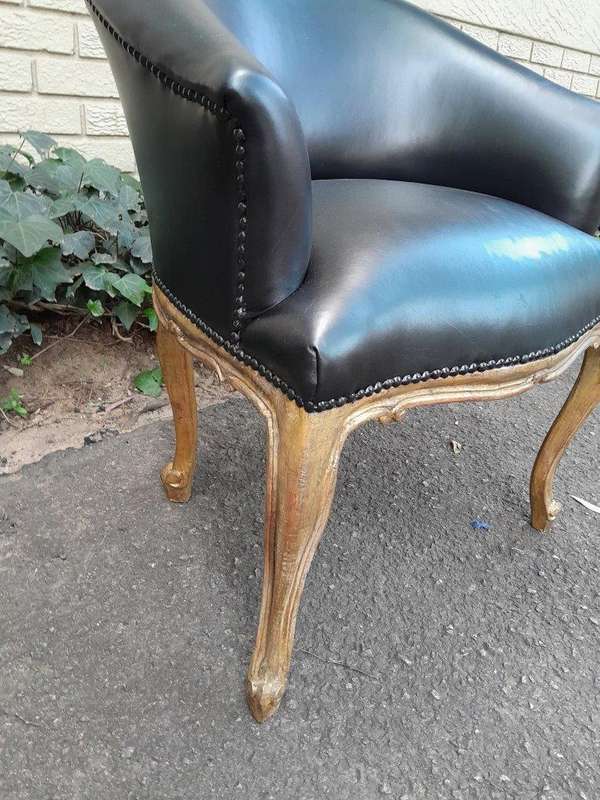 A French Style Pair of Carved Wooden and Hand-Gilded Tub Chairs Upholstered in Black Leather
