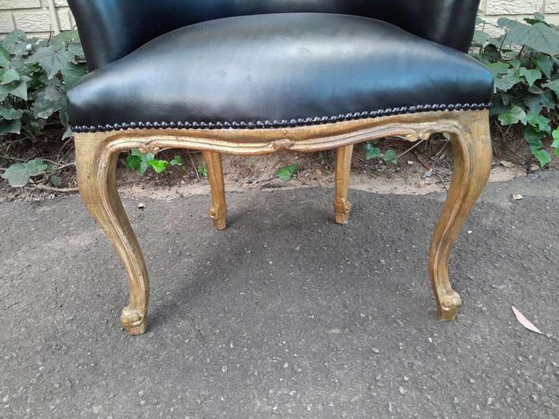 A French Style Pair of Carved Wooden and Hand-Gilded Tub Chairs Upholstered in Black Leather
