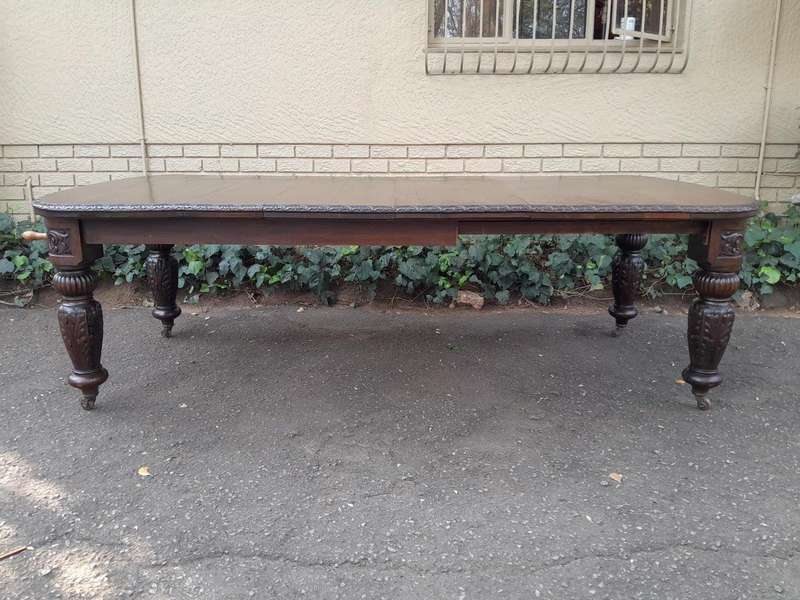 An Antique Victorian English Carved Oak Extending Dining Table on Castors and with Crank Handle