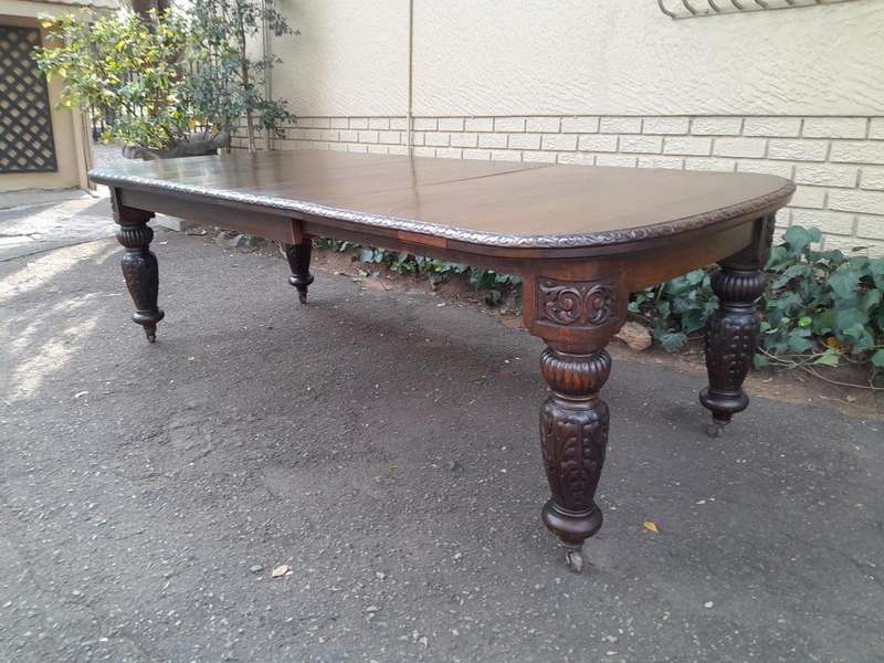 An Antique Victorian English Carved Oak Extending Dining Table on Castors and with Crank Handle