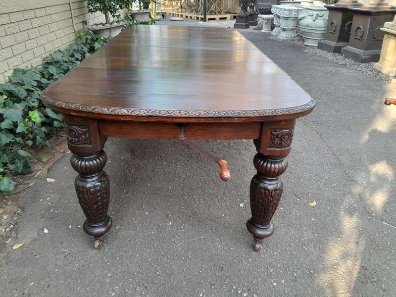 An Antique Victorian English Carved Oak Extending Dining Table on Castors and with Crank Handle