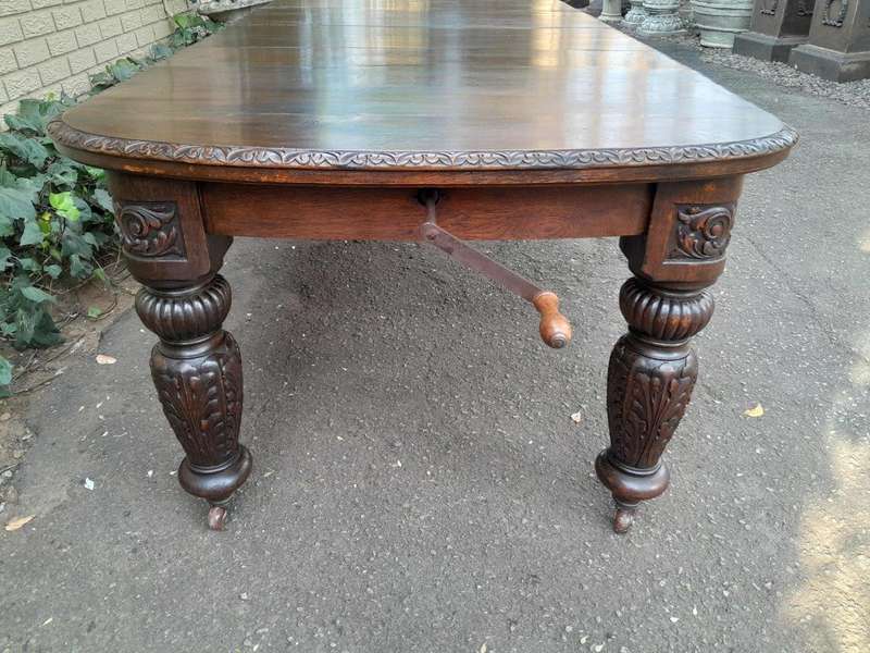 An Antique Victorian English Carved Oak Extending Dining Table on Castors and with Crank Handle